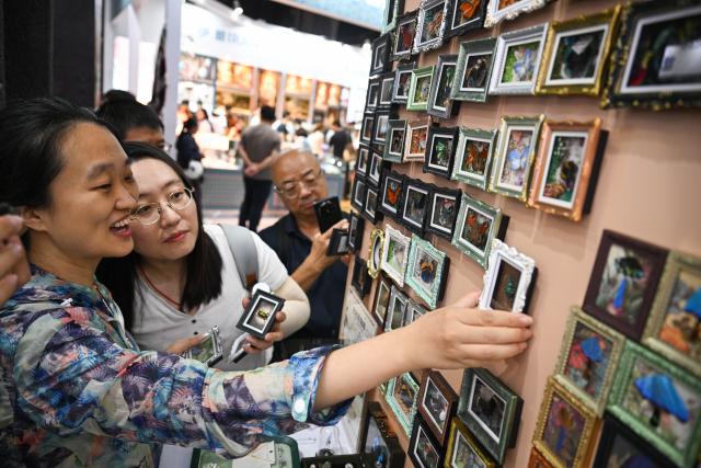 (260912) -- BEIJING, Sept. 12, 2026 (Xinhua) -- Visitors view cultural and creative products made of insect specimens from Peru at the 2026 China International Fair for Trade in Services (CIFTIS) at Shougang Park in Beijing, capital of China, Sept. 12, 2026. The 2026 CIFTIS opens to the general public from Sept. 12 to 13. Visitors with reservation can access the fair free of charge. (Xinhua/Zheng Huansong)