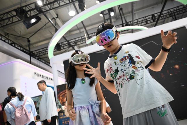 (260912) -- BEIJING, Sept. 12, 2026 (Xinhua) -- Children try VR devices at the themed exhibition area for culture and tourism services during the 2026 China International Fair for Trade in Services (CIFTIS) at Shougang Park in Beijing, capital of China, Sept. 12, 2026. The 2026 CIFTIS, running from Sept. 9 to 13 at Shougang Park in Beijing, has brought together 413 exhibitors at the themed exhibition area for culture and tourism services, showcasing emerging models of cultural and tourism integration. (Xinhua/Zheng Huansong)