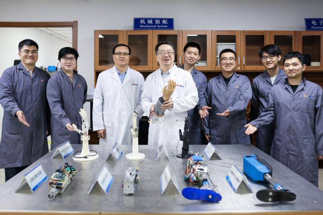 (260912) -- CHANGCHUN, Sept. 12, 2026 (Xinhua) -- Professor Ren Lei (4th L) poses for a group photo with team members at their laboratory in Jilin University in Changchun, northeast China's Jilin Province, Sept. 7, 2026.
  Currently, the bionic embodied intelligent robot team at Jilin University is conducting frontier research on bionic robots. Bringing together researchers from bionics, mechanics, materials, artificial intelligence, computer science, and information engineering, the team has carried out extensive biomechanical testing and modeling analysis, and pioneered the theory and technology of bionic tension-compression body robots internationally. It has developed bionic tension-compression dexterous hands, robotic arms, and complete robot systems.
   "Drawing wisdom from the human body, we are using bionic tension-compression body technology to rebuild the industrial backbone of China's robotics industry, in hopes of truly equipping our robots with human-like dexterity and intelligence," said Ren Lei, academic leader of bionic robotics at Jilin University. (Xinhua/Xu Chang)