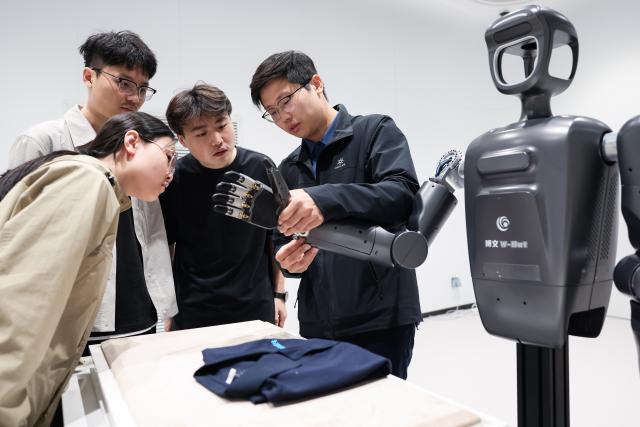 (260912) -- CHANGCHUN, Sept. 12, 2026 (Xinhua) -- Members of a bionic embodied intelligent robot team discuss the control of bionic tension-compression dexterous hands at a bionic robot innovation center in Changchun, northeast China's Jilin Province, Sept. 7, 2026.
  Currently, the bionic embodied intelligent robot team at Jilin University is conducting frontier research on bionic robots. Bringing together researchers from bionics, mechanics, materials, artificial intelligence, computer science, and information engineering, the team has carried out extensive biomechanical testing and modeling analysis, and pioneered the theory and technology of bionic tension-compression body robots internationally. It has developed bionic tension-compression dexterous hands, robotic arms, and complete robot systems.
   "Drawing wisdom from the human body, we are using bionic tension-compression body technology to rebuild the industrial backbone of China's robotics industry, in hopes of truly equipping our robots with human-like dexterity and intelligence," said Ren Lei, academic leader of bionic robotics at Jilin University. (Xinhua/Xu Chang)