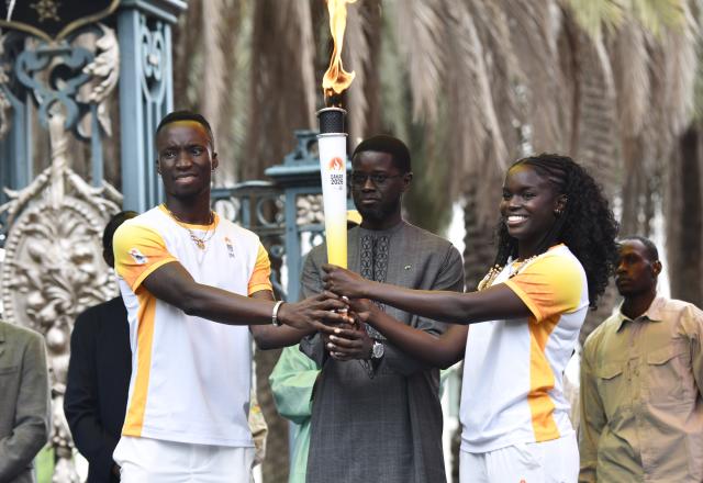 (260912) -- DAKAR, Sept. 12, 2026 (Xinhua) -- Senegalese President Bassirou Diomaye Faye (C) holds the torch during a ceremony to welcome the Youth Olympic flame for the Dakar 2026 Youth Olympic Games outside the Presidential Palace in Dakar, Senegal, Sept. 12, 2026. (Photo by Papa Demba Gueye/Xinhua)