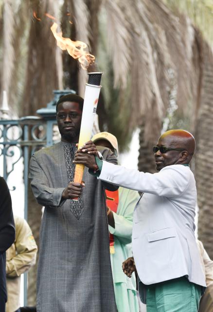 (260912) -- DAKAR, Sept. 12, 2026 (Xinhua) -- Senegalese President Bassirou Diomaye Faye (L) receives the torch from Mamadou Diagna Ndiaye, president of the Dakar 2026 Youth Olympic Games Organising Committee during a ceremony to welcome the Youth Olympic flame for the Dakar 2026 Youth Olympic Games outside the Presidential Palace in Dakar, Senegal, Sept. 12, 2026. (Photo by Papa Demba Gueye/Xinhua)