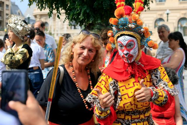 (260912) -- BUCHAREST, Sept. 12, 2026 (Xinhua) -- A Romanian poses with an artist during the Open Streets event under the theme of "Discover Guangxi" to promote the culture and traditions of south China's Guangxi Zhuang Autonomous Region, in Bucharest, Romania, Sept. 12, 2026. (Photo by Cristian Cristel/Xinhua)