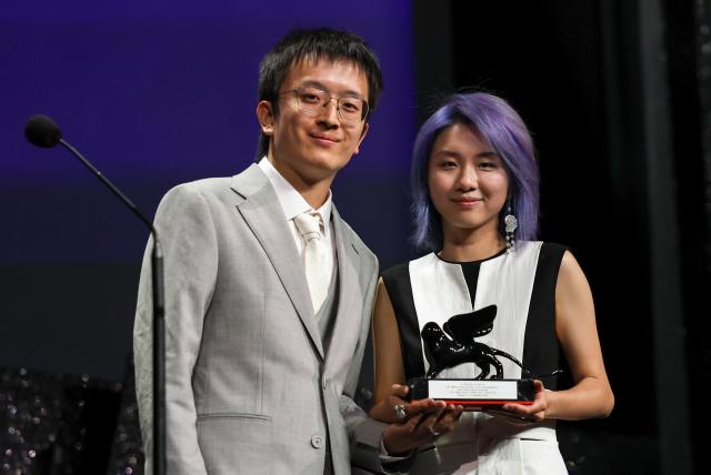 (260912) -- VENICE, Sept. 12, 2026 (Xinhua) -- Director Zhang Yuqi (R) and director Tao Shixin of the short film "The Pigeon Ring" pose with the trophy during the awarding ceremony of the 83rd Venice International Film Festival in Venice, Italy, Sept. 12, 2026. Chinese short film The Pigeon Ring won the Venice Immersive Grand Prize, the top award of the Venice Immersive section, at the 83rd Venice International Film Festival on Saturday. (Xinhua/Wang Kaiyan)