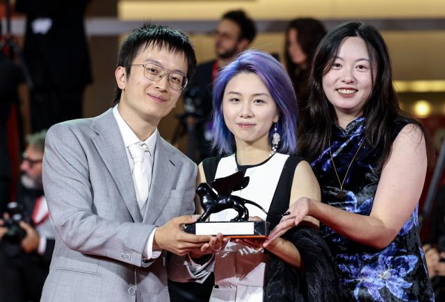 (260912) -- VENICE, Sept. 12, 2026 (Xinhua) -- Main crew of the short film "The Pigeon Ring" pose with the trophy after the awarding ceremony of the 83rd Venice International Film Festival in Venice, Italy, Sept. 12, 2026. Chinese short film The Pigeon Ring won the Venice Immersive Grand Prize, the top award of the Venice Immersive section, at the 83rd Venice International Film Festival on Saturday. (Xinhua/Wang Kaiyan)