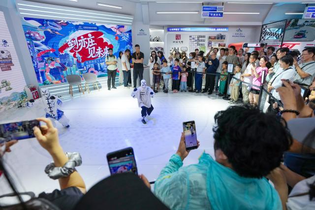 (260913) -- BEIJING, Sept. 13, 2026 (Xinhua) -- Visitors watch a dance staged by robots at the 2026 China International Fair for Trade in Services (CIFTIS) at Shougang Park in Beijing, capital of China, Sept. 12, 2026. The 2026 CIFTIS is open to the general public from Sept. 12 to 13. Visitors with reservation can access the fair free of charge. (Xinhua/Ju Huanzong)