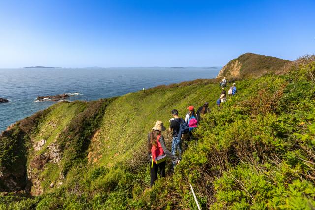 (260913) -- VLADIVOSTOK, Sept. 13, 2026 (Xinhua) -- Tourists hike on Zheltukhin Island, Russia, Sept. 12, 2026. Located in the southern part of the Russian Far East, Zheltukhin Island boasts unique scenery and is popular among tourists. (Photo by Andrey Matveenko/Xinhua)