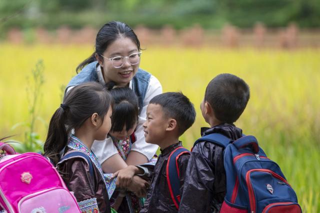 (260913) -- CONGJIANG, Sept. 13, 2026 (Xinhua) -- Peng Hanping escorts students home in Wuying Village on the border between south China's Guangxi Zhuang Autonomous Region and southwest China's Guizhou Province, Sept. 2, 2026. Deep in the mountains on the border between south China's Guangxi Zhuang Autonomous Region and southwest China's Guizhou Province, Wuying Village is far from the township central school. To solve the problem of children having to travel long distances to school, the Wuying teaching site has been retained to this day. This semester it has only two teachers, 56-year-old Pan Xianfeng from Guizhou and 29-year-old Peng Hanping from Guangxi, and 10 students, making it a "micro-primary school." 
   Due to its remote location and harsh conditions, few teachers are willing to teach here for long. Pan applied to transfer here in March 2020 from a better-equipped rural school in Guizhou and Peng followed in September 2023 from a Guangxi primary school. The two, from different provinces and belong to different generations, work in close coordination to keep the school running. 
   Beyond the classroom, they have volunteered at the village night school, teaching local residents literacy and Mandarin, broadening their perspectives and paving way for better livelihoods. 
   "Even with only one student, the teaching site must continue," Pan said firmly. Peng added, "It is all worthwhile so long as the children can go to school nearby, no matter how difficult the work gets." (Photo by Wu Dejun/Xinhua)