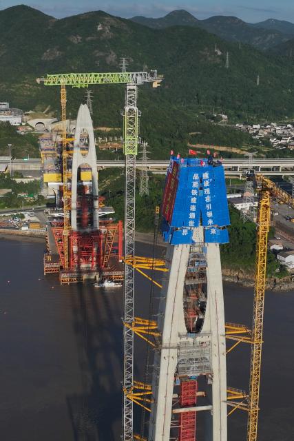 (260913) -- ZHOUSHAN, Sept. 13, 2026 (Xinhua) -- An aerial drone photo taken on Sept. 12, 2026 shows the construction site of the No. 20 main tower of Fuchimen road-rail bridge along Ningbo-Zhoushan Railway in Zhoushan, east China's Zhejiang Province. The main tower, constructed by the China Railway Major Bridge Engineering Group Co., Ltd., was successfully topped out on Sunday, marking the completion of the construction of all six main towers of the three cross-sea bridges of the Ningbo-Zhoushan Railway.
  The main line of the Ningbo-Zhoushan Railway is 76.4 kilometers long, starting from Ningbo East Railway Station in the west and ending at Zhoushan Island in the east, with a designed speed of 250 kilometers per hour. (Xinhua/Huang Zongzhi)