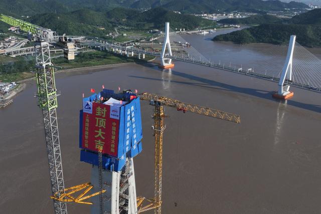 (260913) -- ZHOUSHAN, Sept. 13, 2026 (Xinhua) -- An aerial drone photo taken on Sept. 12, 2026 shows the construction site of the No. 20 main tower of Fuchimen road-rail bridge along Ningbo-Zhoushan Railway in Zhoushan, east China's Zhejiang Province. The main tower, constructed by the China Railway Major Bridge Engineering Group Co., Ltd., was successfully topped out on Sunday, marking the completion of the construction of all six main towers of the three cross-sea bridges of the Ningbo-Zhoushan Railway.
  The main line of the Ningbo-Zhoushan Railway is 76.4 kilometers long, starting from Ningbo East Railway Station in the west and ending at Zhoushan Island in the east, with a designed speed of 250 kilometers per hour. (Xinhua/Huang Zongzhi)