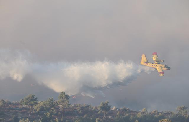 (260913) -- ZAGREB, Sept. 13, 2026 (Xinhua) -- A firefighting plane drops water on a wildfire near the town of Milna on the island of Brac, Croatia, on Sept. 12, 2026. A large wildfire burning on the Croatian island of Brac for days has spread toward villages and tourist facilities overnight, prompting the evacuation of more than 200 people, local media reported Sunday. (Ivo Cagalj/PIXSELL via Xinhua)