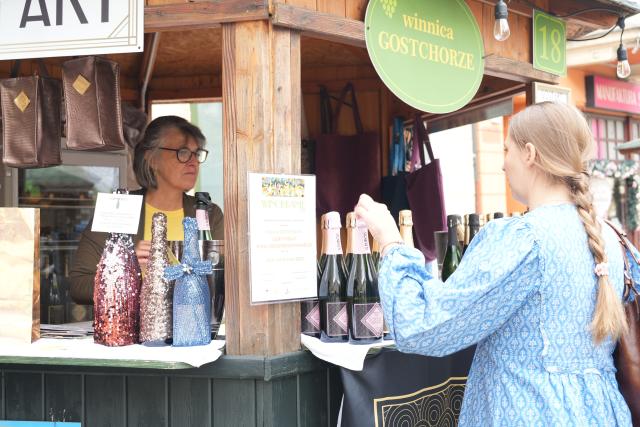 (260913) -- ZIELONA GORA, Sept. 13, 2026 (Xinhua) -- A visitor selects wines at a stall during the Winobranie Wine Festival in Zielona Gora, Poland, Sept. 13, 2026. (Xinhua/Yue Yuanyuan)
