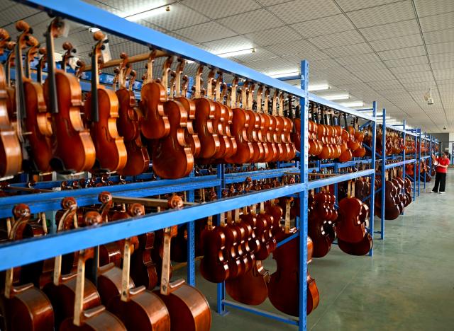 (260913) -- ZHENGZHOU, Sept. 13, 2026 (Xinhua) -- A staff member works at a string instrument manufacturer in Queshan County of Zhumadian City, central China's Henan Province, Sept. 12, 2026. The violin-making industry of Queshan County thrived in recent years as skilled luthiers returned home to start their own businesses. With an annual output of about 400,000 violins, Queshan produces more than 80 percent of made-in-China medium- and high-end violins, violas, cellos, bass and violin accessories. Many violin-related products from Queshan are made for exports to international markets including Italy, the United States, France and Germany. (Xinhua/Hao Yuan)