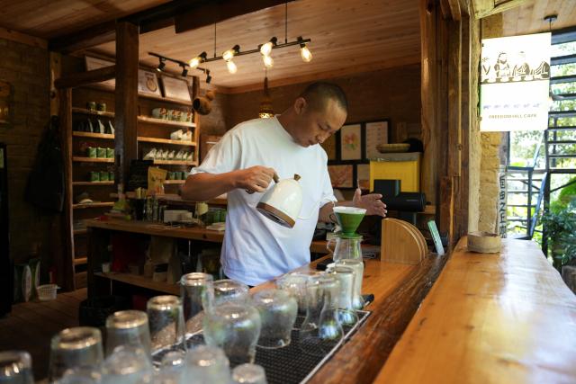 (260914) -- LINCANG, Sept. 14, 2026 (Xinhua) -- A barista makes coffee for customers at Xigui coffee estate in Xigui Village of Lincang City, southwest China's Yunnan Province on Sept. 13, 2026. As one of the important coffee production areas in Yunnan Province, Lincang City, relying on its unique natural resources, has vigorously developed a business model integrating coffee industry and tourism. Tourists can experience coffee culture in an immersive way at the coffee estates, unlocking new experiences of rural leisure.
   By the end of 2025, the coffee planting area in Lincang City had reached approximately 290,000 mu (about 19,333 hectares). The coffee industry is becoming an important engine driving the development of local agricultural, cultural and tourism economy. (Xinhua/Chen Xinbo)