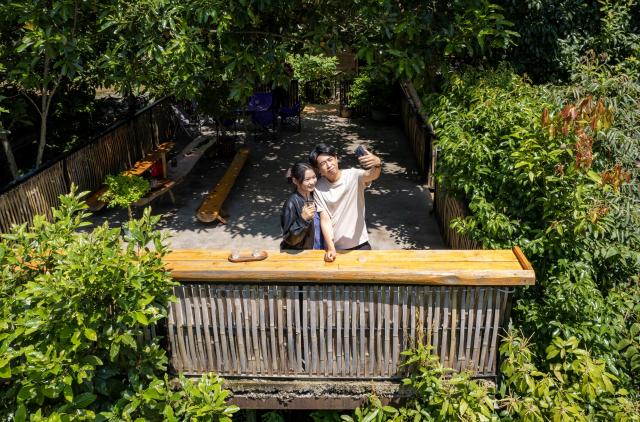 (260914) -- LINCANG, Sept. 14, 2026 (Xinhua) -- A drone photo shows tourists posing for a selfie at Xigui coffee estate in Xigui Village of Lincang City, southwest China's Yunnan Province on Sept. 13, 2026. As one of the important coffee production areas in Yunnan Province, Lincang City, relying on its unique natural resources, has vigorously developed a business model integrating coffee industry and tourism. Tourists can experience coffee culture in an immersive way at the coffee estates, unlocking new experiences of rural leisure.
   By the end of 2025, the coffee planting area in Lincang City had reached approximately 290,000 mu (about 19,333 hectares). The coffee industry is becoming an important engine driving the development of local agricultural, cultural and tourism economy. (Xinhua/Chen Xinbo)