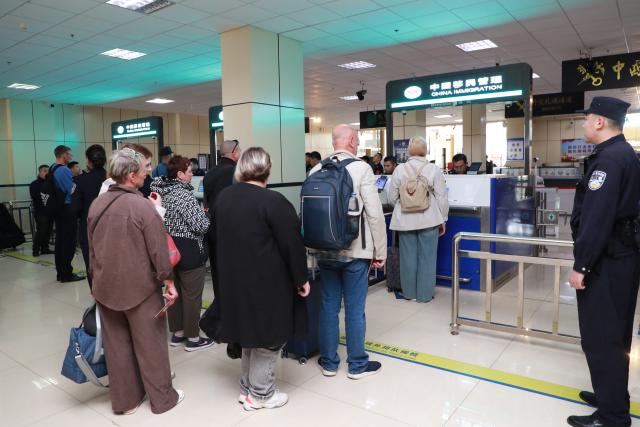 (260914) -- HEIHE, Sept. 14, 2026 (Xinhua) -- Police officers of Heihe border inspection station perform entry inspection for inbound foreign passengers at a port in Heihe, northeast China's Heilongjiang Province, Sept. 14, 2026. Cross-border personnel exchanges at the Heihe Port are getting more and more active since the implementation of the visa-free policy between China and Russia. The number of inbound and outbound passenger trips through the port since the beginning of 2026 has hit a record high of 1 million until Monday, an increase of 56.18 percent year on year. (Photo by Liu Song/Xinhua)
