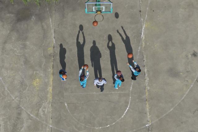 (260914) -- DATONG, Sept. 14, 2026 (Xinhua) -- An aerial drone photo shows Yao Jian (C) and students playing basketball during class break at Sandun Primary School in Sandun Village, Huayuantun Town of Datong, north China's Shanxi Province, Sept. 8, 2026. One day in early autumn, at Sandun Primary School at the foot of the Great Wall section built during the Ming Dynasty (1368-1644) in northern Shanxi, Yao Jian stood on the podium and gave students a lecture. Twenty-eight years have passed since the 52-year-old village teacher began his career at the school. 
  There are only seven teaching staff members and six students at Sandun Primary School, which is located on the border between north China's Shanxi Province and Inner Mongolia Autonomous Region. Tucked away in a remote area and difficult to reach, the school offers children from surrounding villages a vital path to education. 
  In 1998, Yao Jian returned to his hometown and became a teacher after graduating from normal university. Two years later, with outstanding teaching achievements, he was assigned to Sandun Primary School. In 2004, he became the principal of the school, where he also acted as chef, procurement agent and driver.
  When the school was transformed into a boarding school in 2012, he drove his car to pick up and drop off those students who lived far away in all weathers.
  Back in 2002, Yao's wife Ma Lirong moved in to support her husband and take care of these students. Later, Ma also became a teacher there. 
  "Being a teacher is a lifelong undertaking that cannot be taken lightly in the slightest," said Yao Jian. He has developed a special teaching method which combines theoretical knowledge with practice.
  In recent years, the local government has allocated various teaching equipment to the school, while welfare organizations and businesses have also brought teaching and daily necessities. "I want to be like the Great Wall, continuing to stand firm on the front line of rural education and safeguard the children's dreams of education," said Yao. (Xinhua/Yang Chenguang)
