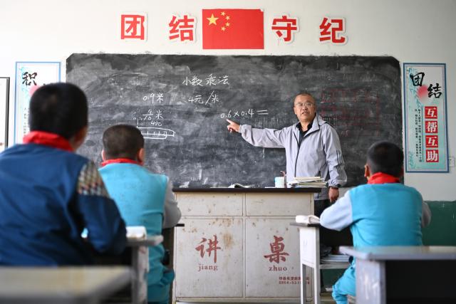 (260914) -- DATONG, Sept. 14, 2026 (Xinhua) -- Yao Jian gives a lecture to students at Sandun Primary School in Sandun Village, Huayuantun Town of Datong, north China's Shanxi Province, Sept. 8, 2026. One day in early autumn, at Sandun Primary School at the foot of the Great Wall section built during the Ming Dynasty (1368-1644) in northern Shanxi, Yao Jian stood on the podium and gave students a lecture. Twenty-eight years have passed since the 52-year-old village teacher began his career at the school. 
  There are only seven teaching staff members and six students at Sandun Primary School, which is located on the border between north China's Shanxi Province and Inner Mongolia Autonomous Region. Tucked away in a remote area and difficult to reach, the school offers children from surrounding villages a vital path to education. 
  In 1998, Yao Jian returned to his hometown and became a teacher after graduating from normal university. Two years later, with outstanding teaching achievements, he was assigned to Sandun Primary School. In 2004, he became the principal of the school, where he also acted as chef, procurement agent and driver.
  When the school was transformed into a boarding school in 2012, he drove his car to pick up and drop off those students who lived far away in all weathers.
  Back in 2002, Yao's wife Ma Lirong moved in to support her husband and take care of these students. Later, Ma also became a teacher there. 
  "Being a teacher is a lifelong undertaking that cannot be taken lightly in the slightest," said Yao Jian. He has developed a special teaching method which combines theoretical knowledge with practice.
  In recent years, the local government has allocated various teaching equipment to the school, while welfare organizations and businesses have also brought teaching and daily necessities. "I want to be like the Great Wall, continuing to stand firm on the front line of rural education and safeguard the children's dreams of education," said Yao. (Xinhua/Hu Qiusi)
