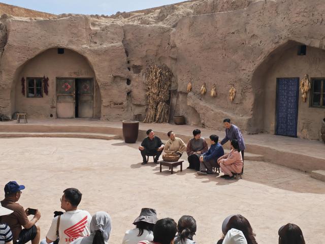 (260914) -- YINCHUAN, Sept. 14, 2026 (Xinhua) -- Tourists watch a play at the "theater village" in Minning Town of Yinchuan, northwest China's Ningxia Hui Autonomous Region, July 1, 2026.
  This year marks the 30th anniversary of paired assistance initiative between southeast China's Fujian Province and northwest China's Ningxia Hui Autonomous Region for targeted poverty alleviation.
   A new "theater village" cultural tourism project has been launched in Minning Town of Yinchuan to commemorate the past three decades of Fujian-Ningxia cooperation. A total of 36 original plays recount the continuous efforts of anti-poverty by Ningxia with help from Fujian over the past 30 years.
   Since the project opened in July this year, it has helped 2,500 local residents nearby secure jobs and increase their incomes. (Xinhua/Ai Fumei)