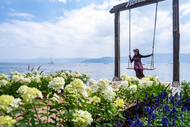 (260915) -- YUXI, Sept. 15, 2026 (Xinhua) -- A tourist enjoys her leisure time at a scenic area on the west bank of Fuxian Lake in Yuxi City, southwest China's Yunnan Province, Sept. 14, 2026. In recent years, local authorities have stepped up efforts to protect ecological environment of Fuxian Lake and developed more lakeside activities, combining the natural scenery with local fishing culture to create more consumption experiences. (Xinhua/Hu Chao)