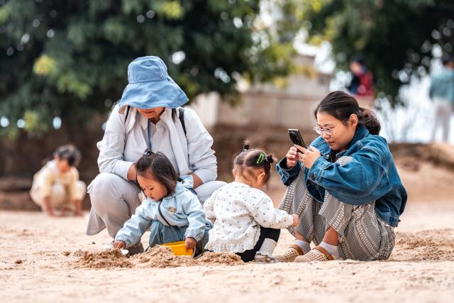 (260915) -- YUXI, Sept. 15, 2026 (Xinhua) -- Tourists enjoy their leisure time at a scenic area on the west bank of Fuxian Lake in Yuxi City, southwest China's Yunnan Province, Sept. 14, 2026. In recent years, local authorities have stepped up efforts to protect ecological environment of Fuxian Lake and developed more lakeside activities, combining the natural scenery with local fishing culture to create more consumption experiences. (Xinhua/Hu Chao)