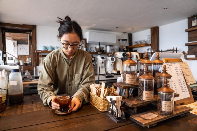 (260915) -- YUXI, Sept. 15, 2026 (Xinhua) -- A staff member serves a cup of coffee to a customer at a cafe at a scenic area on the west bank of Fuxian Lake in Yuxi City, southwest China's Yunnan Province, Sept. 14, 2026. In recent years, local authorities have stepped up efforts to protect ecological environment of Fuxian Lake and developed more lakeside activities, combining the natural scenery with local fishing culture to create more consumption experiences. (Xinhua/Hu Chao)