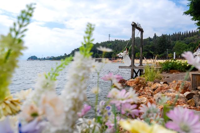 (260915) -- YUXI, Sept. 15, 2026 (Xinhua) -- A tourist poses for photos at a scenic area on the west bank of Fuxian Lake in Yuxi City, southwest China's Yunnan Province, Sept. 14, 2026. In recent years, local authorities have stepped up efforts to protect ecological environment of Fuxian Lake and developed more lakeside activities, combining the natural scenery with local fishing culture to create more consumption experiences. (Xinhua/Hu Chao)