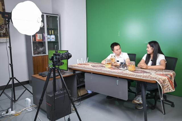 (260915) -- URUMQI, Sept. 15, 2026 (Xinhua) -- Zhang Zhaoyang (L), new media manager of the Urumqi Bonded Exhibition and Trading Center, communicates with Datkaiym Alparova at a livestream studio of the Urumqi Bonded Exhibition and Trading Center in Urumqi, northwest China's Xinjiang Uygur Autonomous Region, Sept. 10, 2026.
  Datkaiym Alparova, who hails from Bishkek, Kyrgyzstan, is majoring in international economics and trade at Xinjiang Normal University. Entering her senior year, the 21-year-old undergraduate began receiving practical training on cross-border e-commerce livestreaming at the Urumqi Bonded Exhibition and Trading Center. 
  The center features imported goods from dozens of countries and regions. It has also provided practical training for international students, including cross-border e-commerce livestreaming, store operations and market research, said Zhang Zhaoyang, the center's new media manager. 
  "I promote honey from Kyrgyzstan to customers in Chinese via livestreaming, which makes the learning experience more immersive," Datkaiym said. Such practice has deepened her understanding of international trade. 
  Online shopping has long been part of Datkaiym's daily life. "Whether in Urumqi or Bishkek, I often buy daily items through livestream," Datkaiym said. "Many people in my hometown also use online platforms like Pinduoduo and Taobao." 
  After graduation, Datkaiym hopes to apply her professional knowledge and language skills in cross-border trade between China and Kyrgyzstan. (Xinhua/Hu Huhu)