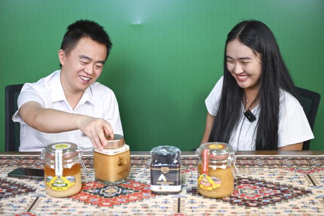 (260915) -- URUMQI, Sept. 15, 2026 (Xinhua) -- Zhang Zhaoyang (L), new media manager of the Urumqi Bonded Exhibition and Trading Center, and Datkaiym Alparova introduce honey from Kyrgyzstan at a livestream studio of the Urumqi Bonded Exhibition and Trading Center in Urumqi, northwest China's Xinjiang Uygur Autonomous Region, Sept. 10, 2026.
  Datkaiym Alparova, who hails from Bishkek, Kyrgyzstan, is majoring in international economics and trade at Xinjiang Normal University. Entering her senior year, the 21-year-old undergraduate began receiving practical training on cross-border e-commerce livestreaming at the Urumqi Bonded Exhibition and Trading Center. 
  The center features imported goods from dozens of countries and regions. It has also provided practical training for international students, including cross-border e-commerce livestreaming, store operations and market research, said Zhang Zhaoyang, the center's new media manager. 
  "I promote honey from Kyrgyzstan to customers in Chinese via livestreaming, which makes the learning experience more immersive," Datkaiym said. Such practice has deepened her understanding of international trade. 
  Online shopping has long been part of Datkaiym's daily life. "Whether in Urumqi or Bishkek, I often buy daily items through livestream," Datkaiym said. "Many people in my hometown also use online platforms like Pinduoduo and Taobao." 
  After graduation, Datkaiym hopes to apply her professional knowledge and language skills in cross-border trade between China and Kyrgyzstan. (Xinhua/Hu Huhu)