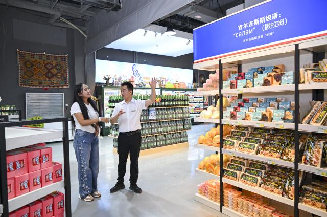(260915) -- URUMQI, Sept. 15, 2026 (Xinhua) -- Datkaiym Alparova (L) communicates with Zhang Zhaoyang, new media manager of the Urumqi Bonded Exhibition and Trading Center, in Urumqi, northwest China's Xinjiang Uygur Autonomous Region, Sept. 10, 2026.
  Datkaiym Alparova, who hails from Bishkek, Kyrgyzstan, is majoring in international economics and trade at Xinjiang Normal University. Entering her senior year, the 21-year-old undergraduate began receiving practical training on cross-border e-commerce livestreaming at the Urumqi Bonded Exhibition and Trading Center. 
  The center features imported goods from dozens of countries and regions. It has also provided practical training for international students, including cross-border e-commerce livestreaming, store operations and market research, said Zhang Zhaoyang, the center's new media manager. 
  "I promote honey from Kyrgyzstan to customers in Chinese via livestreaming, which makes the learning experience more immersive," Datkaiym said. Such practice has deepened her understanding of international trade. 
  Online shopping has long been part of Datkaiym's daily life. "Whether in Urumqi or Bishkek, I often buy daily items through livestream," Datkaiym said. "Many people in my hometown also use online platforms like Pinduoduo and Taobao." 
  After graduation, Datkaiym hopes to apply her professional knowledge and language skills in cross-border trade between China and Kyrgyzstan. (Xinhua/Hu Huhu)