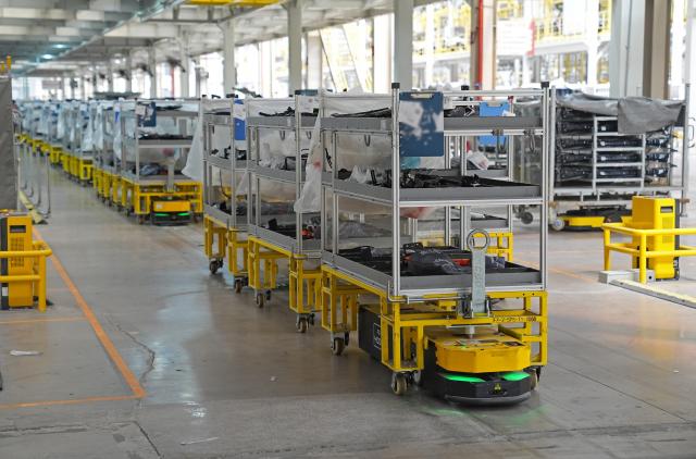 (260915) -- FUZHOU, Sept. 15, 2026 (Xinhua) -- Automated guided vehicles transport components at the BYD Fuzhou base in Fuzhou, east China's Jiangxi Province, Sept. 9, 2026. In the workshop of Chinese automaker BYD's Fuzhou base in Jiangxi, stamping, welding, painting and final assembly processes operate efficiently. Industrial robots and automated guided vehicles work in coordination, achieving full-process digital control. (Xinhua/Wan Xiang)