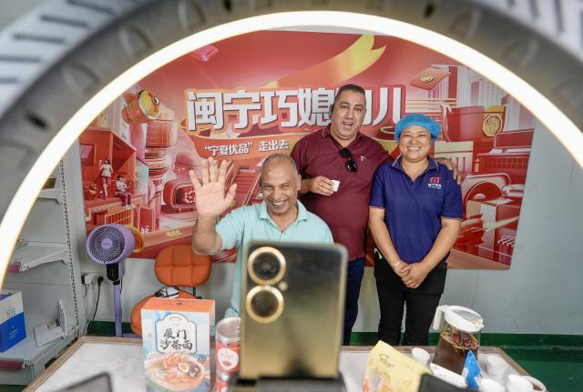 (260915) -- YINCHUAN, Sept. 15, 2026 (Xinhua) -- A foreign guest greets the audience at a livestreaming studio of Minning Hemei e-commerce workshop in Minning Town of Yinchuan, northwest China's Ningxia Hui Autonomous Region, July 10, 2026. (Xinhua/Yang Zhisen)