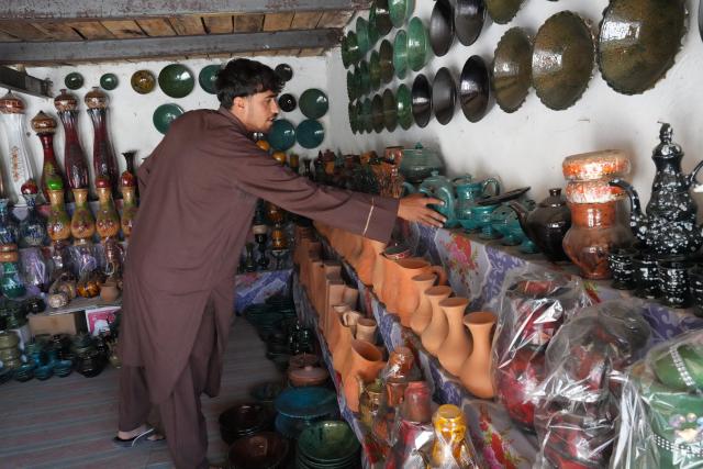 (260915) -- ISTALIF, Sept. 15, 2026 (Xinhua) -- A shopkeeper arranges traditional pottery and ceramic products at a shop in Kabul, Afghanistan, Sept. 13, 2026. TO GO WITH "Feature: Afghanistan's ancient pottery craft fights for survival" (Photo by Saifurahman Safi/Xinhua)