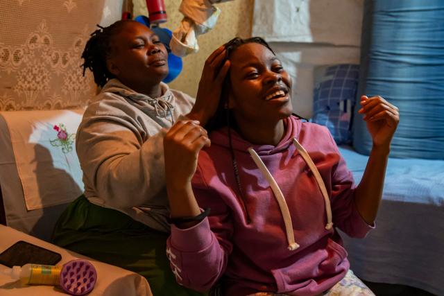 (260915) -- NAIROBI, Sept. 15, 2026 (Xinhua) -- Miriam Achieng Kenyatta's mother (L) massages her daughter's head at Kibera informal settlement in Nairobi, Kenya, Sept. 8, 2026. Miriam Achieng Kenyatta, a 23-year-old geospatial engineering student at the University of Nairobi, received a warm reception upon returning home after making history at the 25th "Chinese Bridge" Chinese Proficiency Competition for Foreign College Students.
  Raised in Nairobi's Kibera informal settlement, Achieng's life trajectory was transformed by a childhood curiosity sparked by a television movie. Her passion culminated in the highest-ever ranking by a Kenyan in the prestigious global contest, where she placed among the Top 15 worldwide.
  TO GO WITH "From Kibera to world top 15: Kenyan student makes history in Chinese competition" (Xinhua/Xie Jianfei)