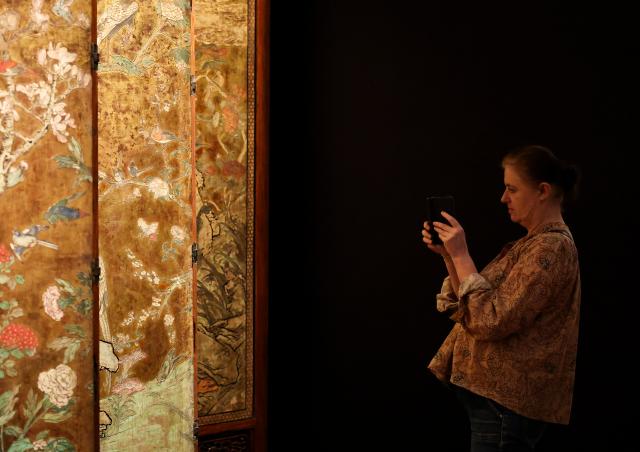 (260915) -- PARIS, Sept. 15, 2026 (Xinhua) -- A visitor takes photos of an exhibit on display at Maison Guimet in Paris, France, Sept. 15, 2026. Maison Guimet is housed in the Hotel d'Heidelbach, a private mansion built in 1913. The mansion became part of the Guimet National Museum of Asian Arts in 1991 and reopened to the public as Maison Guimet in May, 2026 following renovation. (Xinhua/Wu Huiwo)