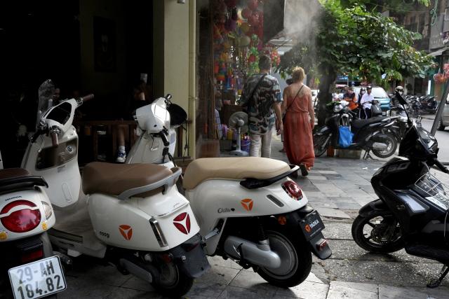 (260916) -- HANOI, Sept. 16, 2026 (Xinhua) -- This photo taken on Aug. 20, 2026 shows Yadea electric two-wheelers parked outside a coffee shop in Hanoi, Vietnam. TO GO WITH "Feature: Chinese e-motorcycles ride through Vietnam's green transition" (Xinhua/Liu Ying)