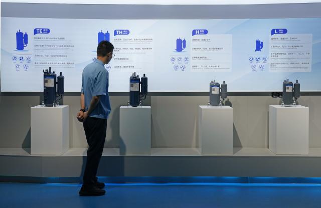 (260916) -- NANCHANG, Sept. 16, 2026 (Xinhua) -- A technician looks at samples of air conditioner compressors at Highly Group's production base in Nanchang, east China's Jiangxi Province, Aug. 20, 2026. Smart, digitalized production has been fully realized at the Nanchang production base of electric appliance manufacturer Highly Group, a leading intelligent manufacturing base for air conditioner compressors. On average, the base produces a compressor every 6.5 seconds. Highly Group exports air conditioner compressors to 165 countries and regions worldwide, accounting for nearly one-seventh of the global market share. (Xinhua/Wan Xiang)
