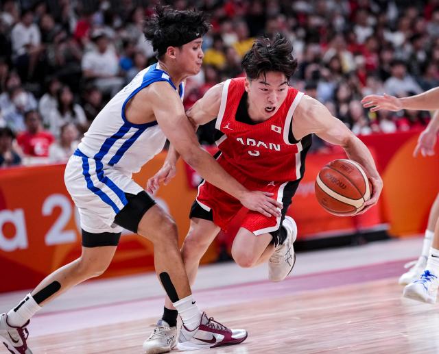 (260916) -- NAGOYA, Sept. 16, 2026 (Xinhua) -- Kurokawa Kotetsu (R) of Japan breaks through during the quarterfinal match of men's basketball between Japan and Chinese Taipei at the 20th Asian Games Aichi-Nagoya 2026 in Nagoya, Japan, Sept. 16, 2026. (Xinhua/Luo Yuan)