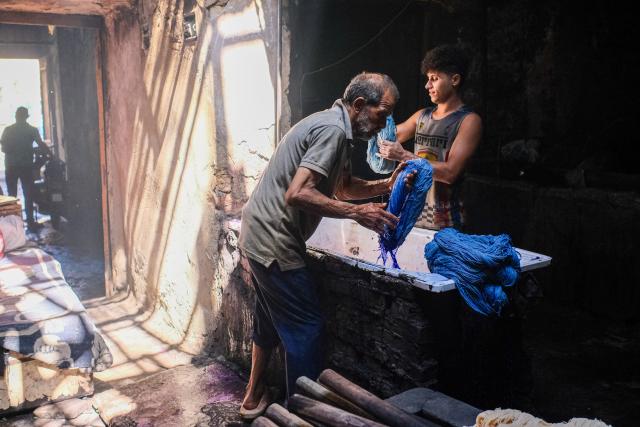 (260917) -- CAIRO, Sept. 17, 2026 (Xinhua) -- Craftsmen dye skeins of yarn at a traditional dyehouse in Cairo, Egypt, Sept. 16, 2026. Established in 1901, Uncle Salama's Dyehouse is among the few remaining traditional dye houses in Egypt. As industrial textile production has expanded, such workshops have become increasingly rare. (Xinhua/Xin Mengchen)