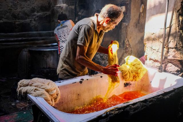 (260917) -- CAIRO, Sept. 17, 2026 (Xinhua) -- A craftsman dyes skeins of yarn at a traditional dyehouse in Cairo, Egypt, Sept. 16, 2026. Established in 1901, Uncle Salama's Dyehouse is among the few remaining traditional dye houses in Egypt. As industrial textile production has expanded, such workshops have become increasingly rare. (Xinhua/Xin Mengchen)