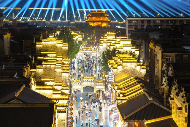 (260917) -- XIANGYANG, Sept. 17, 2026 (Xinhua) -- People visit Xiangyang ancient town at night in Xiangyang, central China's Hubei Province, Sept. 16, 2026. In recent years, Xiangyang in central China's Hubei Province has been promoting tourism through light shows, evening cruises, live performances and night markets. The city has also integrated its historical and cultural heritage into tourism, offering visitors a richer experience that blends local history with vibrant street life. (Xinhua/Xiao Yijiu)