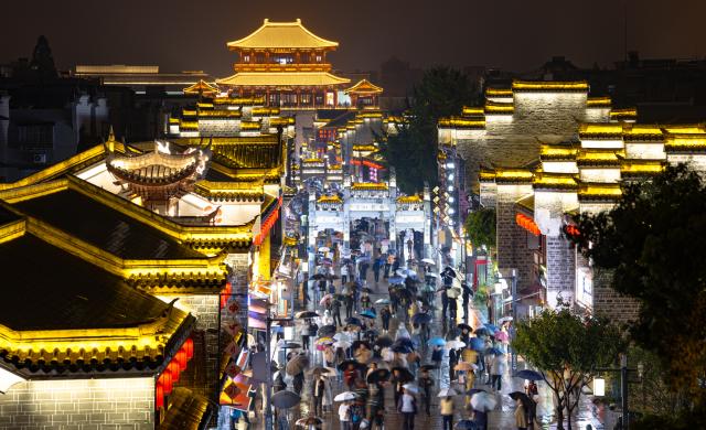 (260917) -- XIANGYANG, Sept. 17, 2026 (Xinhua) -- People visit Xiangyang ancient town at night in Xiangyang, central China's Hubei Province, Sept. 16, 2026. In recent years, Xiangyang in central China's Hubei Province has been promoting tourism through light shows, evening cruises, live performances and night markets. The city has also integrated its historical and cultural heritage into tourism, offering visitors a richer experience that blends local history with vibrant street life. (Xinhua/Xiao Yijiu)
