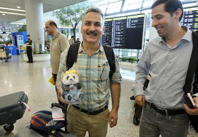 (260917) -- SHANGHAI, Sept. 17, 2026 (Xinhua) -- A member of Iranian delegation for the 48th WorldSkills Competition (L) shows a doll panda he has just bought upon his arrival at Shanghai Pudong International Airport in Shanghai, east China, Sept. 17, 2026. The 48th WorldSkills Competition is scheduled to take place from September 22 to 27 in Shanghai. (Xinhua/Fang Zhe)