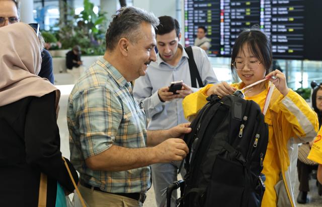(260917) -- SHANGHAI, Sept. 17, 2026 (Xinhua) -- A volunteer helps a member of Iranian delegation for the 48th WorldSkills Competition attach a bag tag upon his arrival at Shanghai Pudong International Airport in Shanghai, east China, Sept. 17, 2026. The 48th WorldSkills Competition is scheduled to take place from September 22 to 27 in Shanghai. (Xinhua/Fang Zhe)