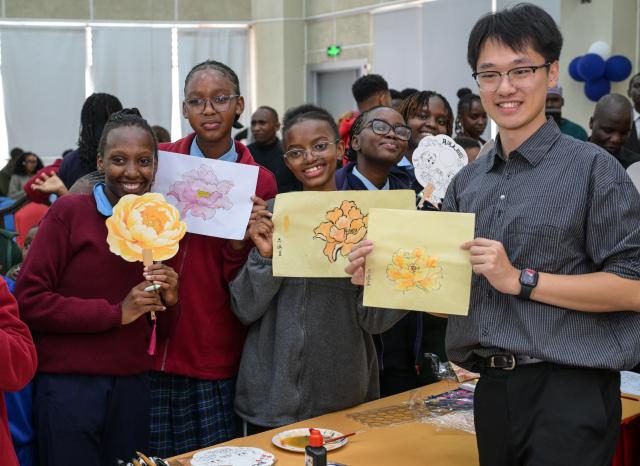 (260917) -- NAIROBI, Sept. 17, 2026 (Xinhua) -- Students display peony-themed paintings with their teacher during an event to celebrate the upcoming Mid-Autumn Festival at the Confucius Institute at Kenyatta University in Nairobi, Kenya, Sept. 16, 2026. TO GO WITH "Feature: Kenyan youth embrace China's Mid-Autumn Festival as cultural ties grow" (Xinhua/Yang Guang)