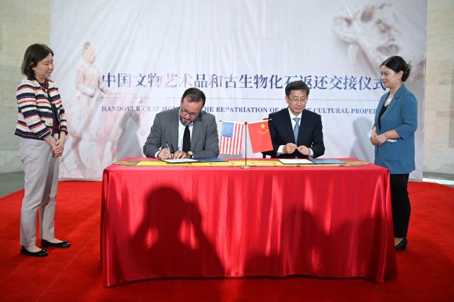 (260918) -- WASHINGTON, Sept. 18, 2026 (Xinhua) -- Rao Quan (2nd R), vice minister of Culture and Tourism and administrator of China's National Cultural Heritage Administration, signs the confirmation of the return and receipt of Chinese cultural property with a U.S. representative in Washington, D.C., the United States, Sept. 16, 2026. The United States has returned 64 Chinese cultural relics and paleontological fossils to China, China's National Cultural Heritage Administration (NCHA) said Thursday.
   The items were handed over in two batches in Washington and New York on Wednesday and Thursday by Homeland Security Investigations (HSI) and the Manhattan District Attorney's Office, respectively. (Xinhua/Li Rui)