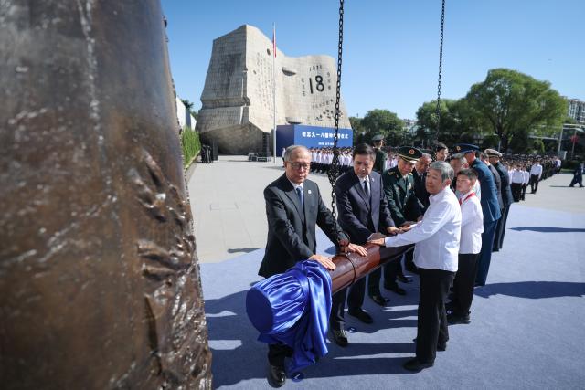 (260918) -- SHENYANG, Sept. 18, 2026 (Xinhua) -- Li Hongzhong, vice chairman of the National People's Congress Standing Committee and a member of the Political Bureau of the Communist Party of China Central Committee, and representatives from all walks of life toll the Bell of Warning during a ceremony marking the 95th anniversary of the September 18 Incident at the square of the 9.18 Historical Museum in Shenyang, northeast China's Liaoning Province, Sept. 18, 2026. Li attended the ceremony and delivered a speech. (Xinhua/Pan Yulong)