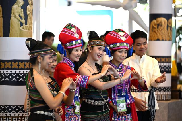 (260918) -- NANNING, Sept. 18, 2026 (Xinhua) -- Actors from Laos pose for photos with exhibitors during the 23rd China-ASEAN Expo in Nanning, south China's Guangxi Zhuang Autonomous Region, Sept. 18, 2026. Various cultural performances have become highlights of the ongoing 23rd China-ASEAN Expo. (Xinhua/Huang Xiaobang)