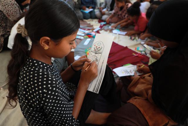 (260918) -- GAZA, Sept. 18, 2026 (Xinhua) -- A Palestinian child attends a drawing and coloring activity as part of the "Dream Bus" initiative, run by the Palestine Red Crescent Society, in Al-Shati refugee camp, west of Gaza City, on Sept. 17, 2026. TO GO WITH "Feature: From ambulance to cinema -- Gaza kids find brief respite beside 'Dream Bus'" (Photo by Rizek Abdeljawad/Xinhua)