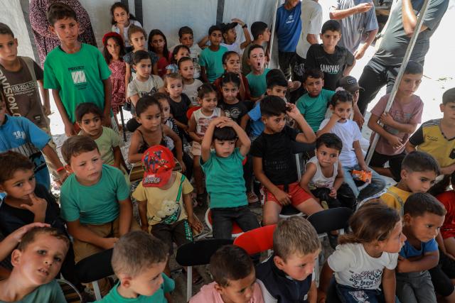 (260918) -- GAZA, Sept. 18, 2026 (Xinhua) -- Palestinian children attend a recreational activity as part of the "Dream Bus" initiative, run by the Palestine Red Crescent Society, in Al-Shati refugee camp, west of Gaza City, on Sept. 17, 2026. TO GO WITH "Feature: From ambulance to cinema -- Gaza kids find brief respite beside 'Dream Bus'" (Photo by Rizek Abdeljawad/Xinhua)